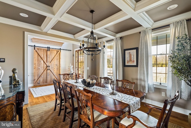 dining area featuring hardwood / wood-style flooring, crown molding, coffered ceiling, a barn door, and beamed ceiling