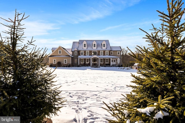 view of snow covered back of property