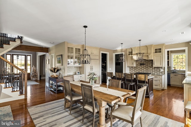 dining room with dark hardwood / wood-style flooring, plenty of natural light, and a chandelier