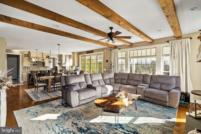 living room with ceiling fan, dark hardwood / wood-style floors, and beam ceiling