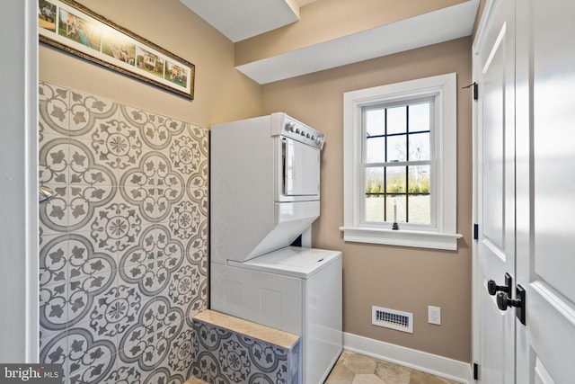 clothes washing area featuring stacked washer / dryer