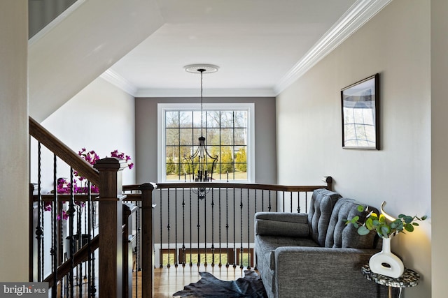 living area with crown molding and a chandelier