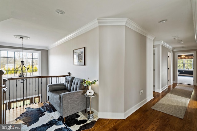 hallway featuring crown molding, dark hardwood / wood-style floors, and an inviting chandelier