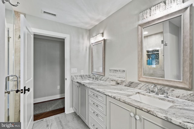 bathroom with a shower with door and vanity