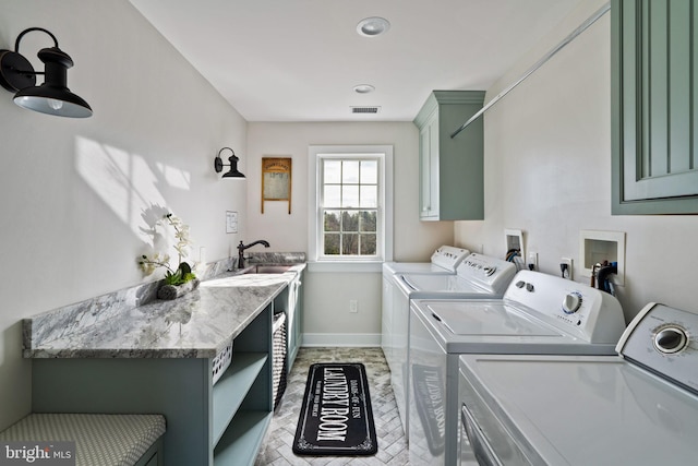 washroom with cabinets, sink, and washer and dryer