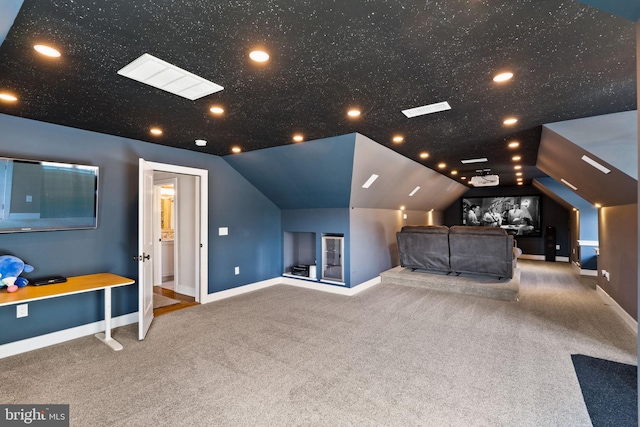 carpeted home theater room featuring lofted ceiling