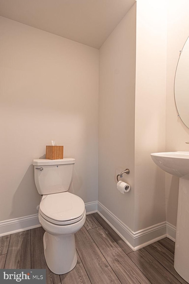 bathroom featuring wood-type flooring and toilet