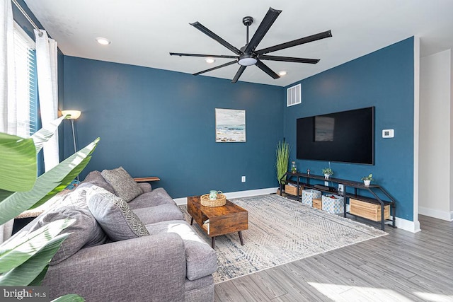 living room with wood-type flooring and ceiling fan