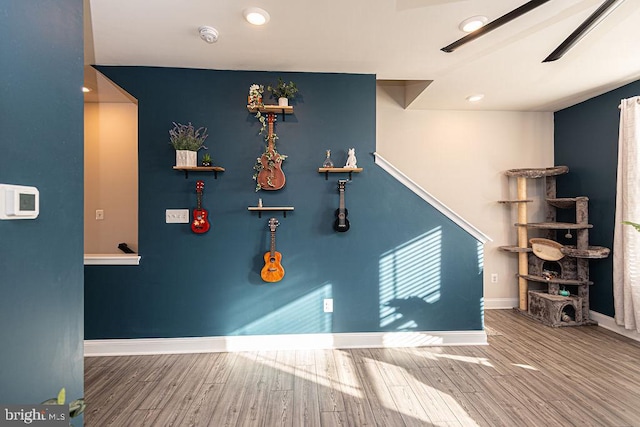 game room featuring wood-type flooring and ceiling fan