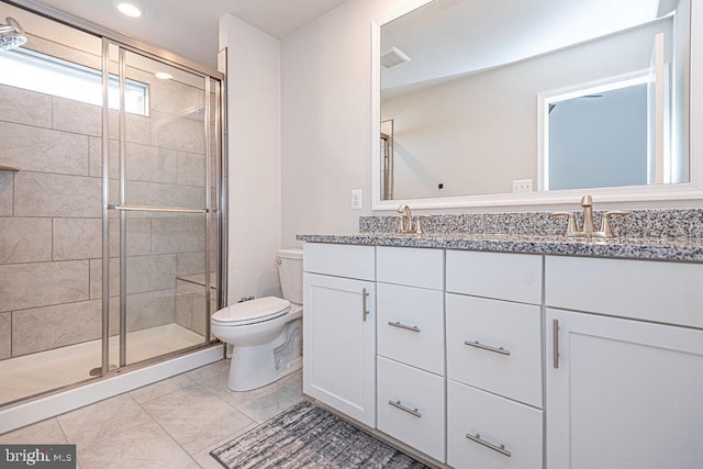 bathroom featuring vanity, a shower with shower door, and toilet