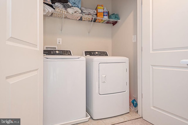 laundry room featuring separate washer and dryer and light tile patterned floors