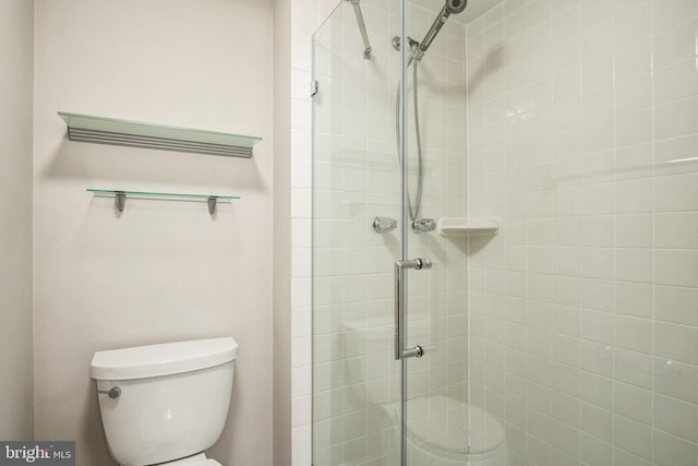 bathroom with a shower stall and toilet