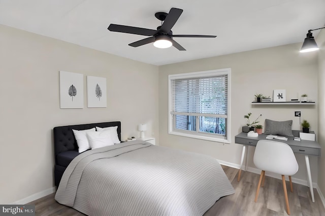 bedroom featuring wood finished floors, a ceiling fan, and baseboards