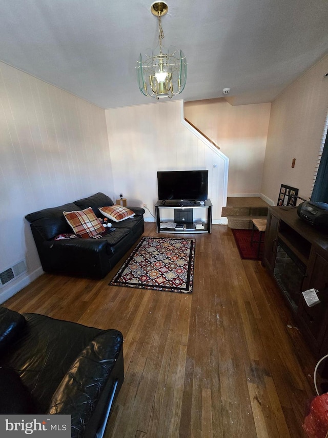 living room with dark wood-type flooring and an inviting chandelier