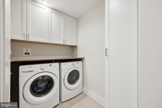 laundry area with cabinets, separate washer and dryer, and light hardwood / wood-style floors