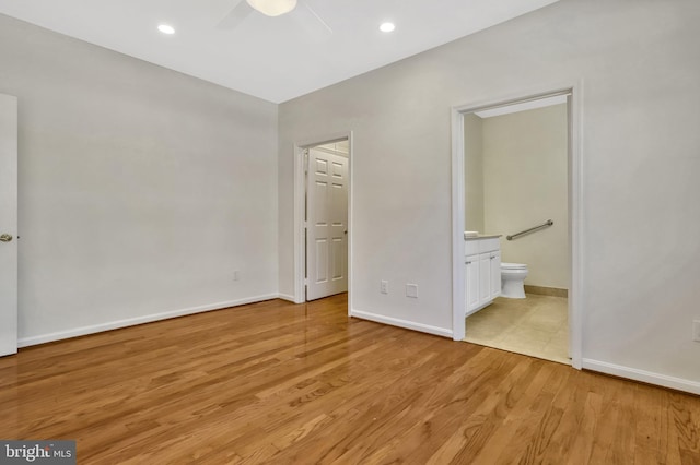 unfurnished bedroom featuring ceiling fan, connected bathroom, and light hardwood / wood-style floors