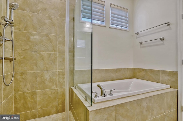 bathroom featuring shower with separate bathtub