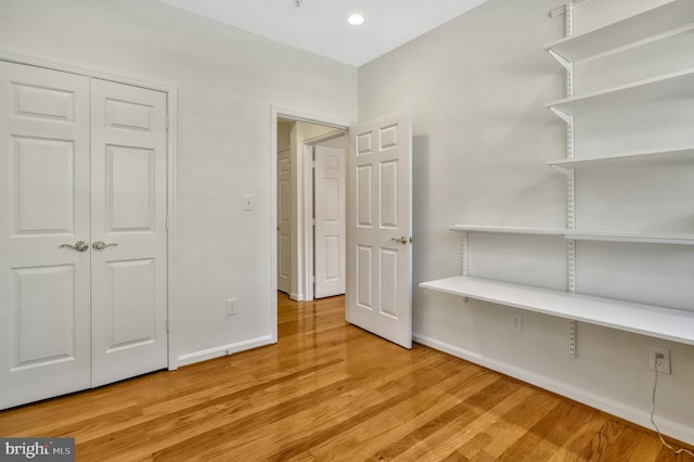 unfurnished bedroom featuring hardwood / wood-style floors and a closet