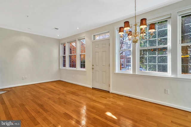 interior space with crown molding, hardwood / wood-style floors, and an inviting chandelier