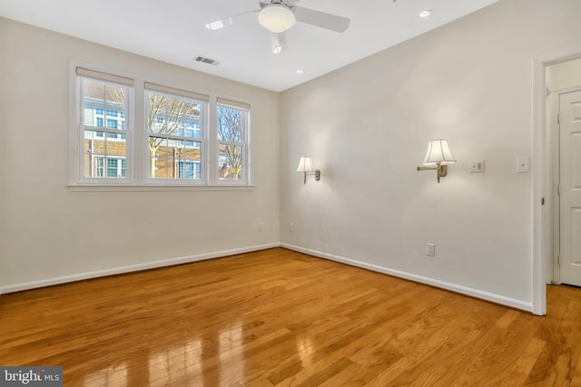 empty room with ceiling fan and light hardwood / wood-style flooring