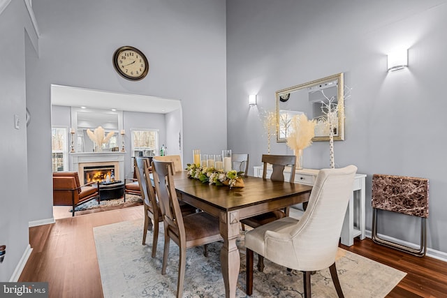 dining room with dark hardwood / wood-style flooring and a towering ceiling