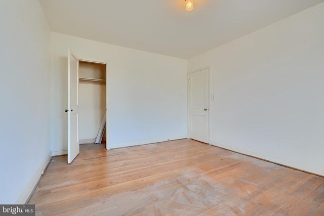 unfurnished bedroom with light hardwood / wood-style flooring and a closet