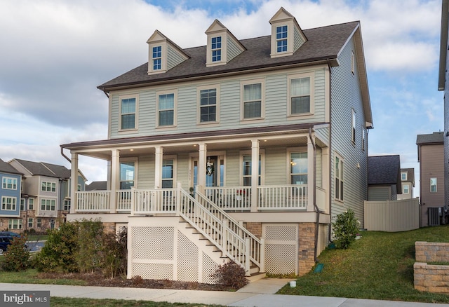 view of front of home with a porch, central AC, and a front yard