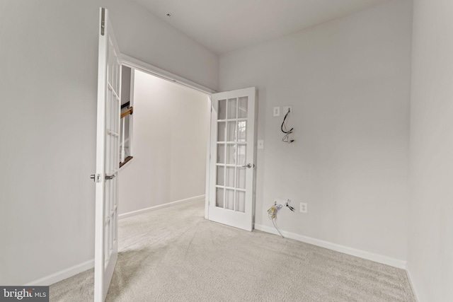 carpeted spare room featuring french doors