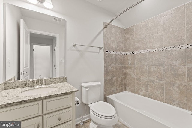 full bathroom featuring tiled shower / bath, vanity, and toilet