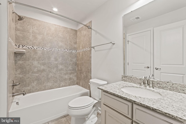 full bathroom with vanity, tiled shower / bath combo, tile patterned floors, and toilet