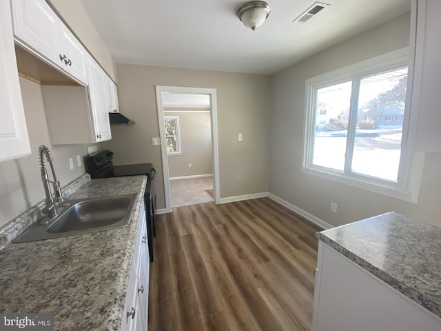 kitchen with white cabinetry, sink, black range with electric cooktop, and dark hardwood / wood-style floors