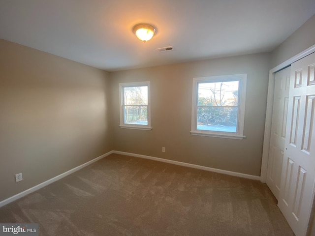 unfurnished bedroom with carpet floors and a closet