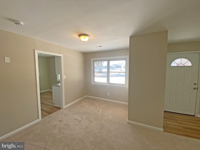 foyer entrance featuring light colored carpet