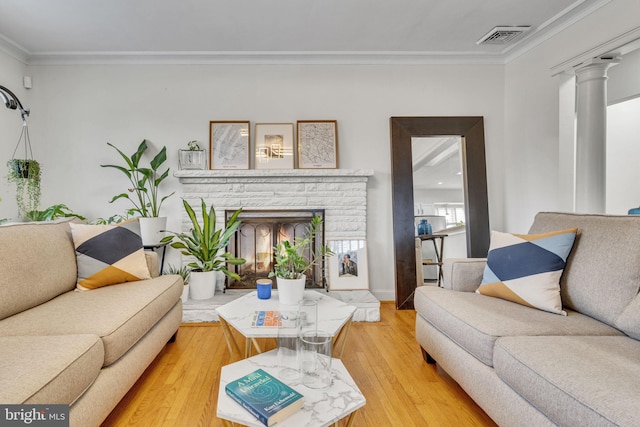 living room featuring hardwood / wood-style floors, ornamental molding, and decorative columns