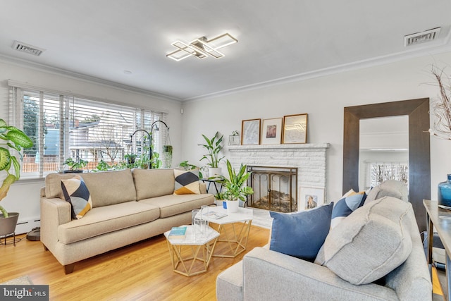 living room with baseboard heating, ornamental molding, hardwood / wood-style floors, and a brick fireplace