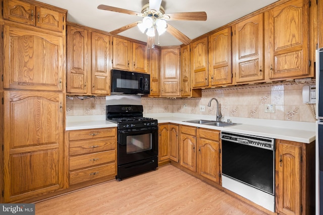 kitchen featuring black appliances, sink, backsplash, ceiling fan, and light hardwood / wood-style floors