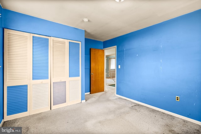 unfurnished bedroom with light colored carpet and a closet