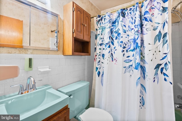 bathroom with vanity, toilet, a shower with shower curtain, and tile walls