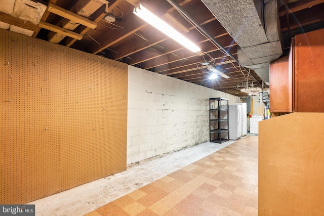 basement featuring washer / clothes dryer and white fridge