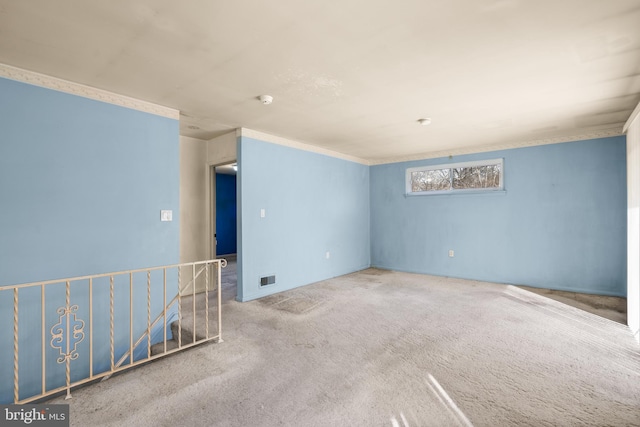 carpeted empty room featuring crown molding