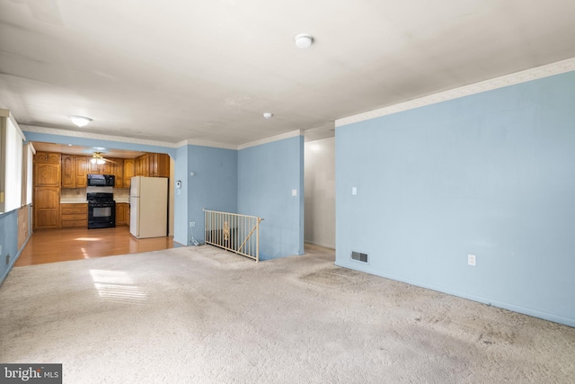 unfurnished living room with ornamental molding, light carpet, and ceiling fan