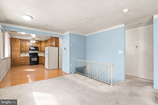 kitchen featuring crown molding, ceiling fan, light hardwood / wood-style flooring, and black appliances