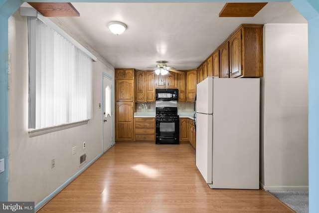 kitchen with backsplash, ceiling fan, light hardwood / wood-style flooring, and black appliances