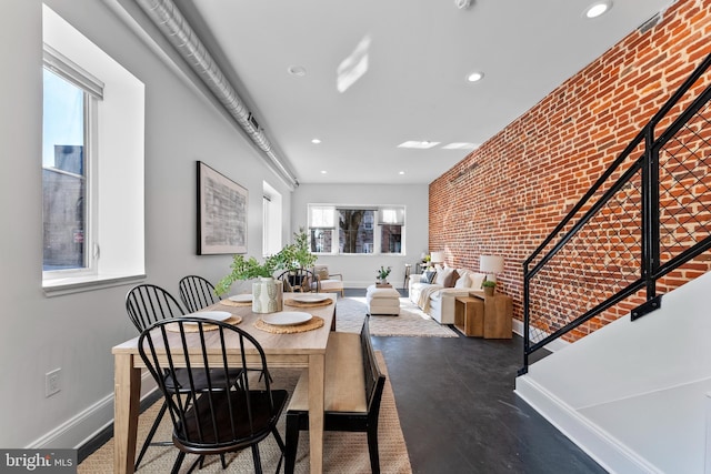 dining area featuring concrete flooring and brick wall