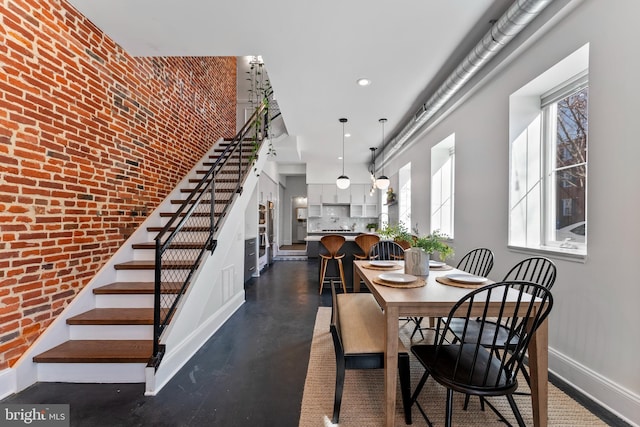 dining room featuring brick wall