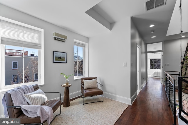 sitting room featuring plenty of natural light and dark wood-type flooring