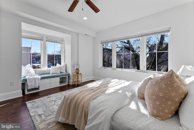 bedroom featuring multiple windows, dark wood-type flooring, and ceiling fan