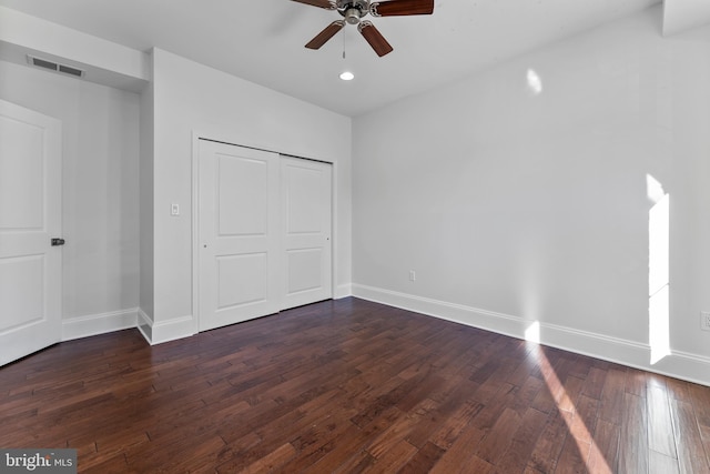 unfurnished bedroom with dark hardwood / wood-style floors, ceiling fan, and a closet