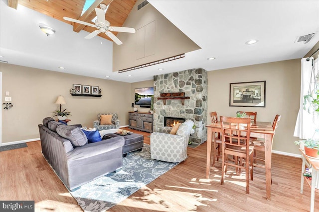 living room featuring ceiling fan, hardwood / wood-style floors, and a fireplace