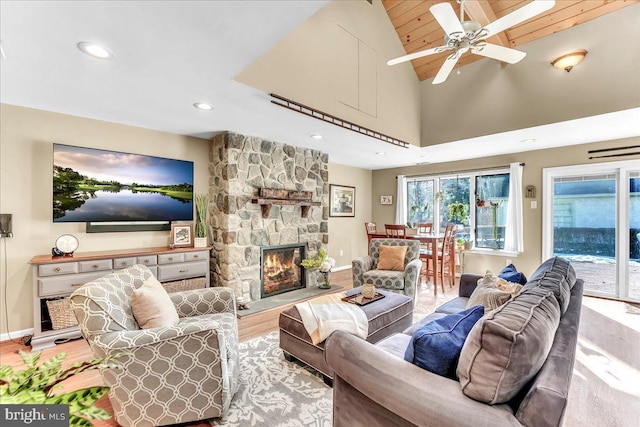 living room featuring wood ceiling, high vaulted ceiling, hardwood / wood-style flooring, ceiling fan, and a fireplace